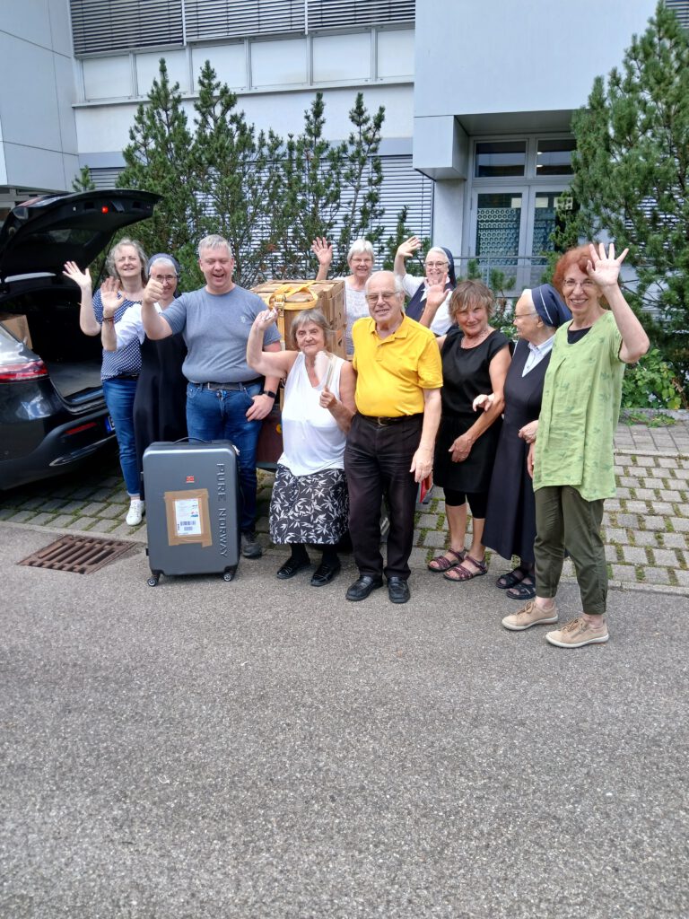 Gruppenbild der Helferinnen und Helfer des Aktionstags Äthiopien 2025 in Schwäbisch Gmünd, die lachend und winkend neben Schuhspenden und einem Koffer stehen.