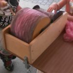 Auf der Kardiermaschine "RUDY" wird gerade gefärbte Wolle aufbereitet