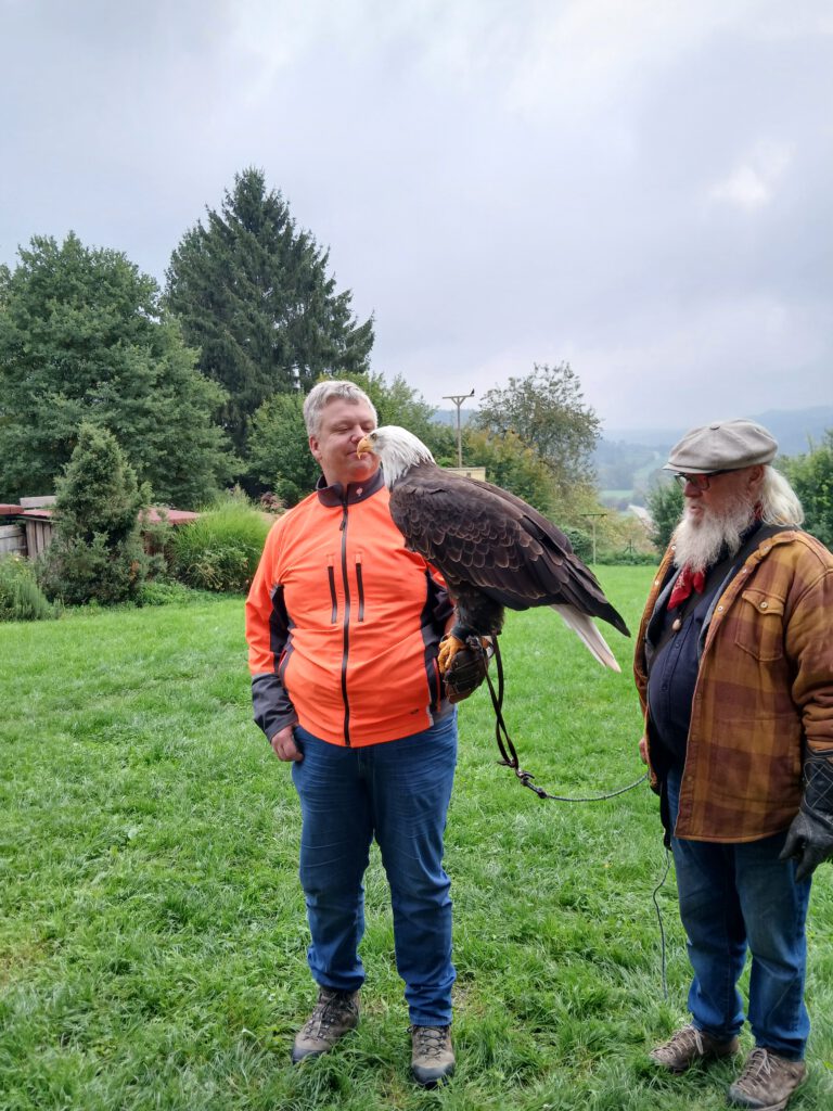 Zwei Personen mit einem Greifvogel auf der Hand bei einem Leadership-Workshop in der Stauferfalknerei Lorch – Begegnung auf Augenhöhe zwischen Mensch und Tier.
