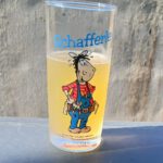 Ein Glas Apfelschorle im Schafferle-Glas auf einem Grill mit Thermometer an einem heißen Sommertag – erfrischend mit Bio-Apfelsaft von regionalen Streuobstwiesen.